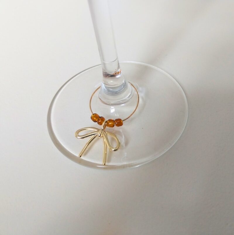 Wine glass markers gift set of six with colored beads and bow detail. A stylish, practical gift for hosts and party lovers. Reusable and ready to impress.