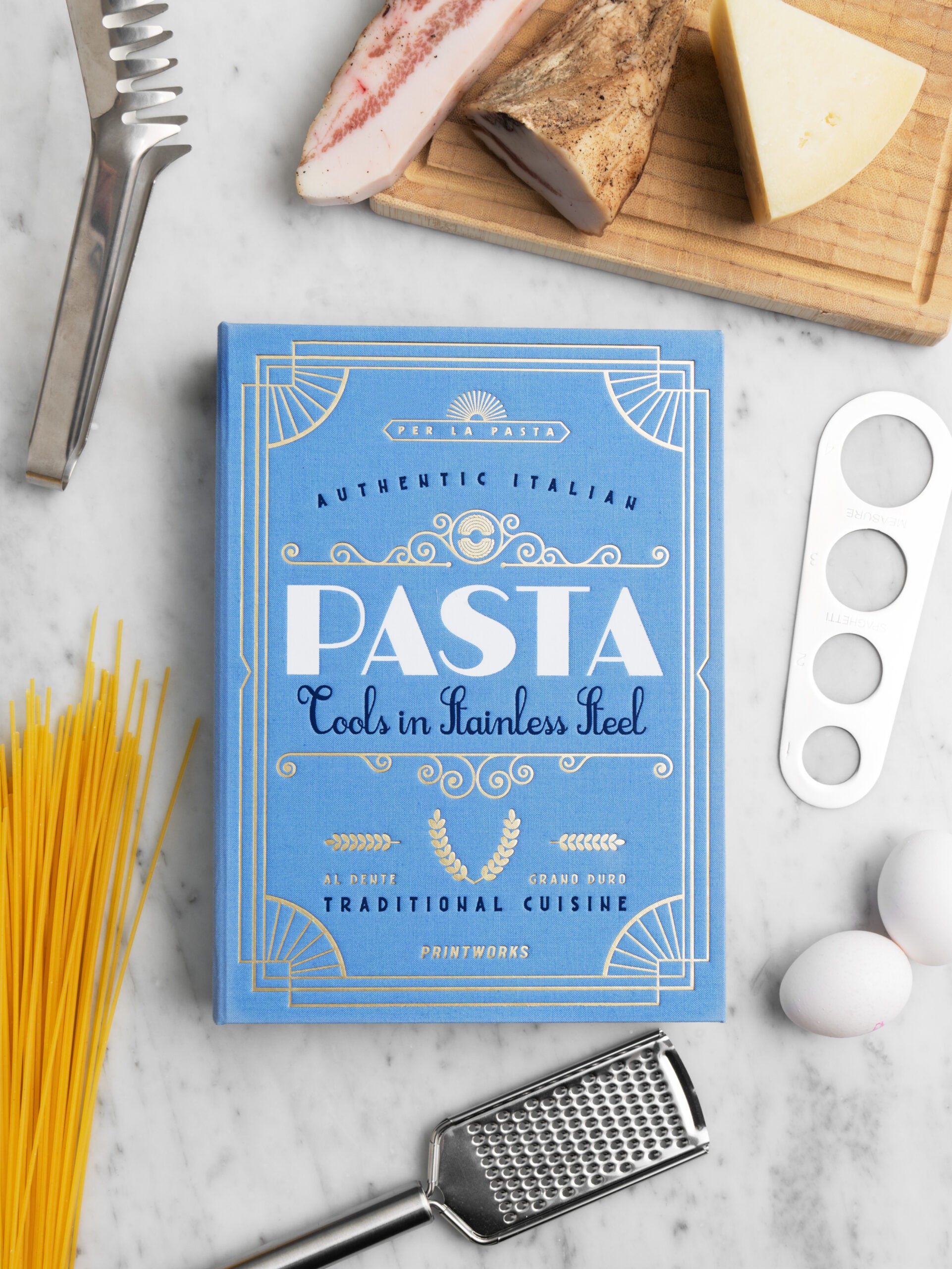 Pasta gift set in bright blue book-style box with stainless steel spaghetti measurer, tongs and grater – luxury gift