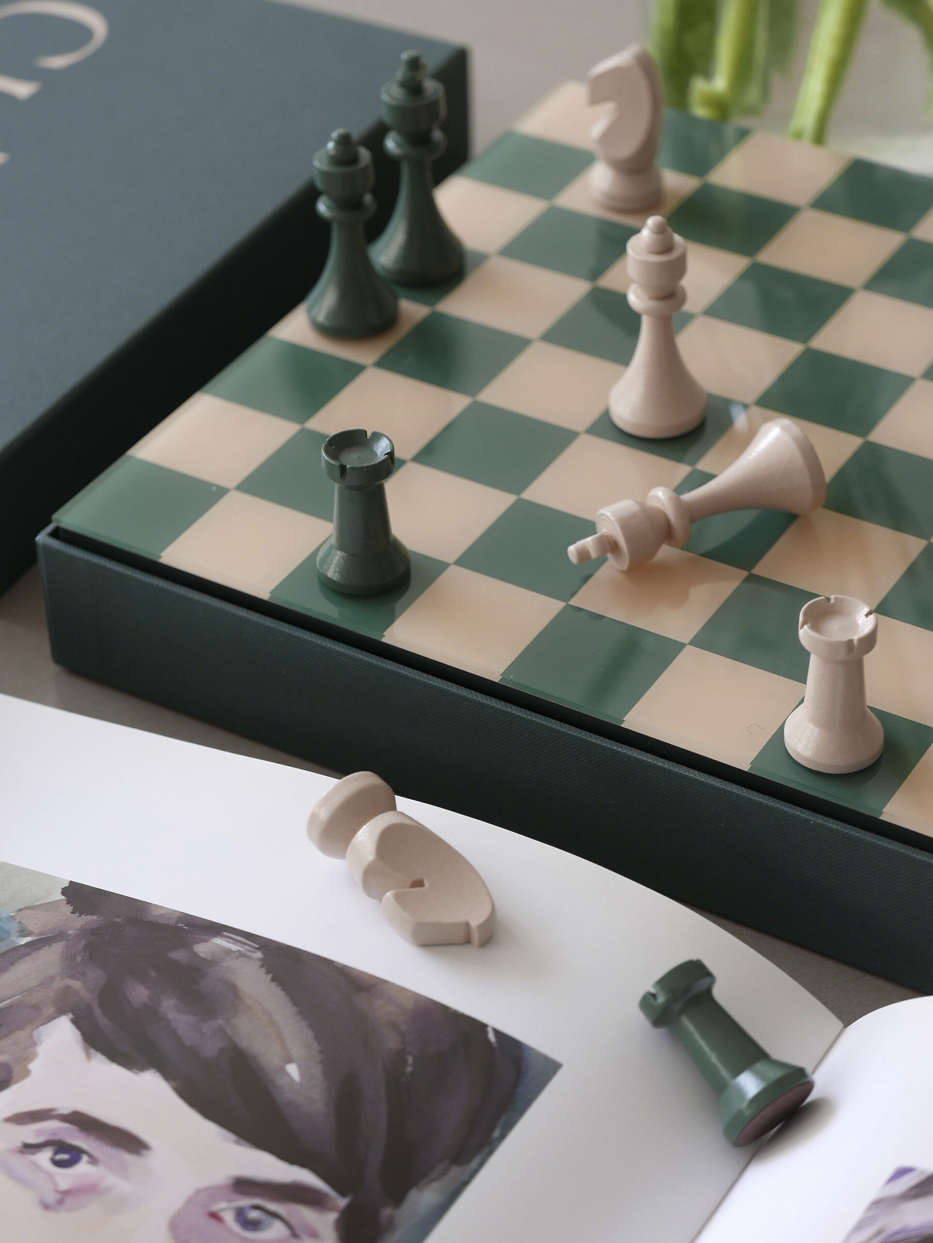 Chess board game with wooden pieces and green acrylic-topped board