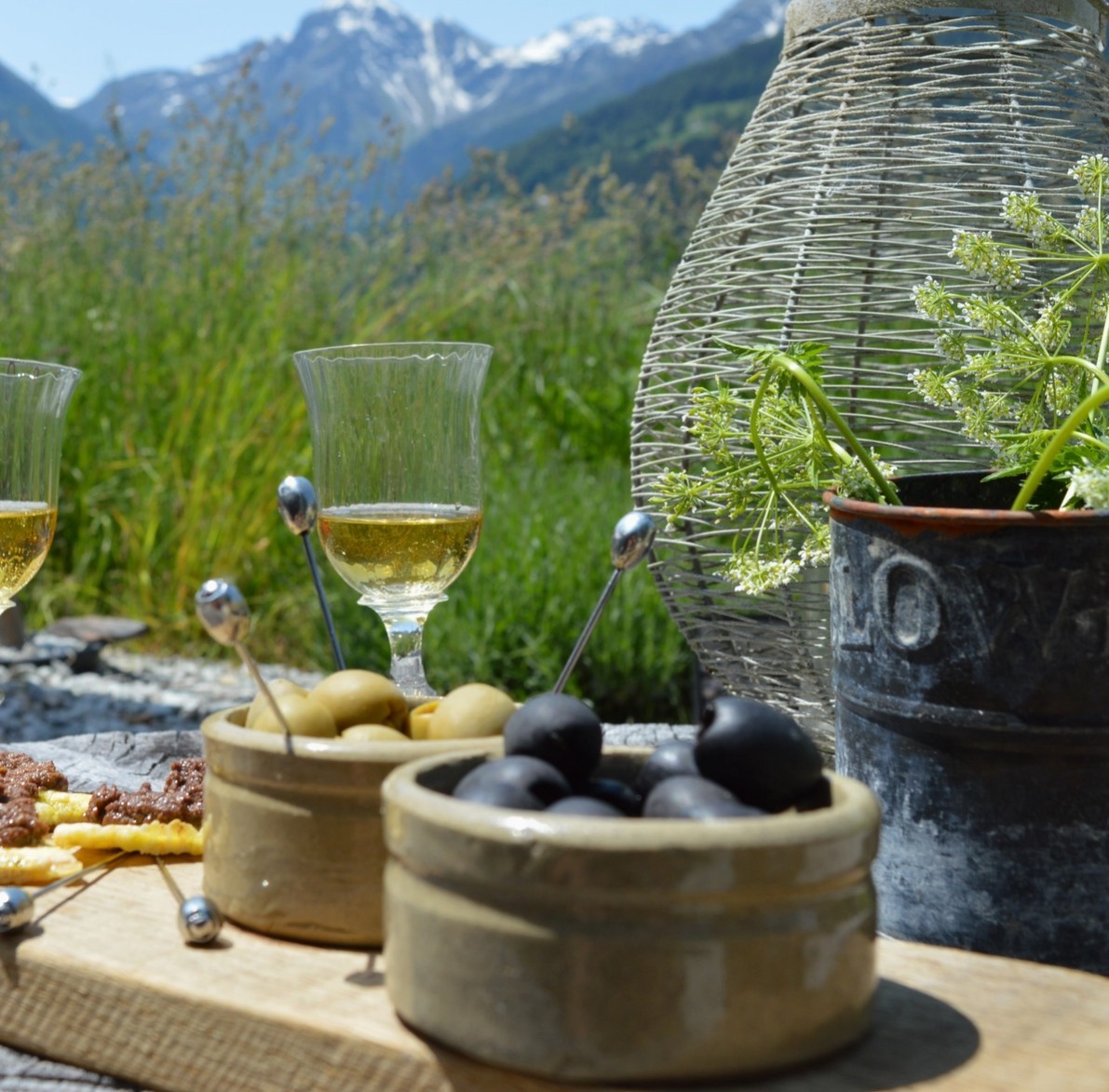 Handcrafted olive tapas picks in olives with a glass of wine