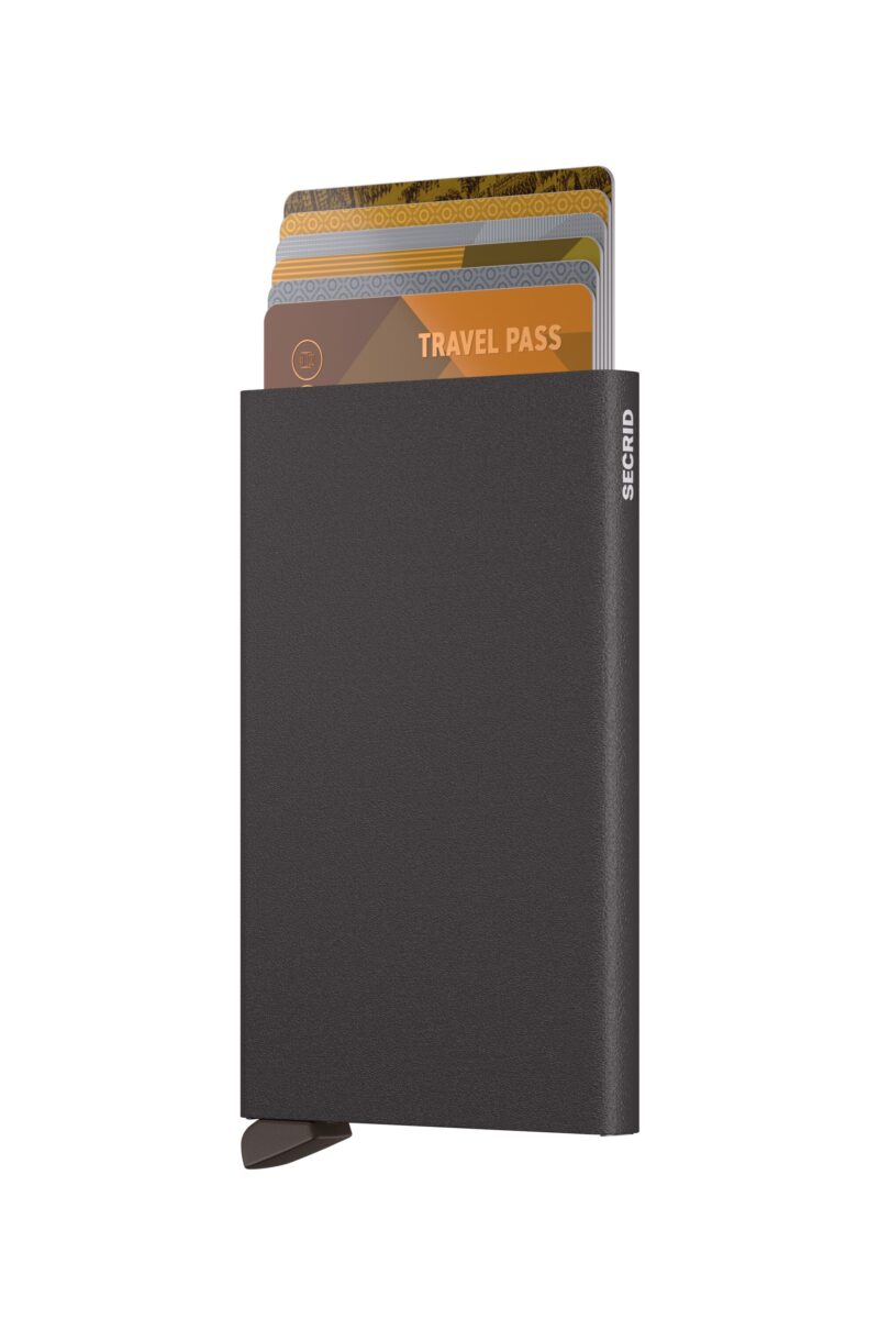 Brown aluminium card holder with patented quick-access mechanism, photographed in a clean and modern style.