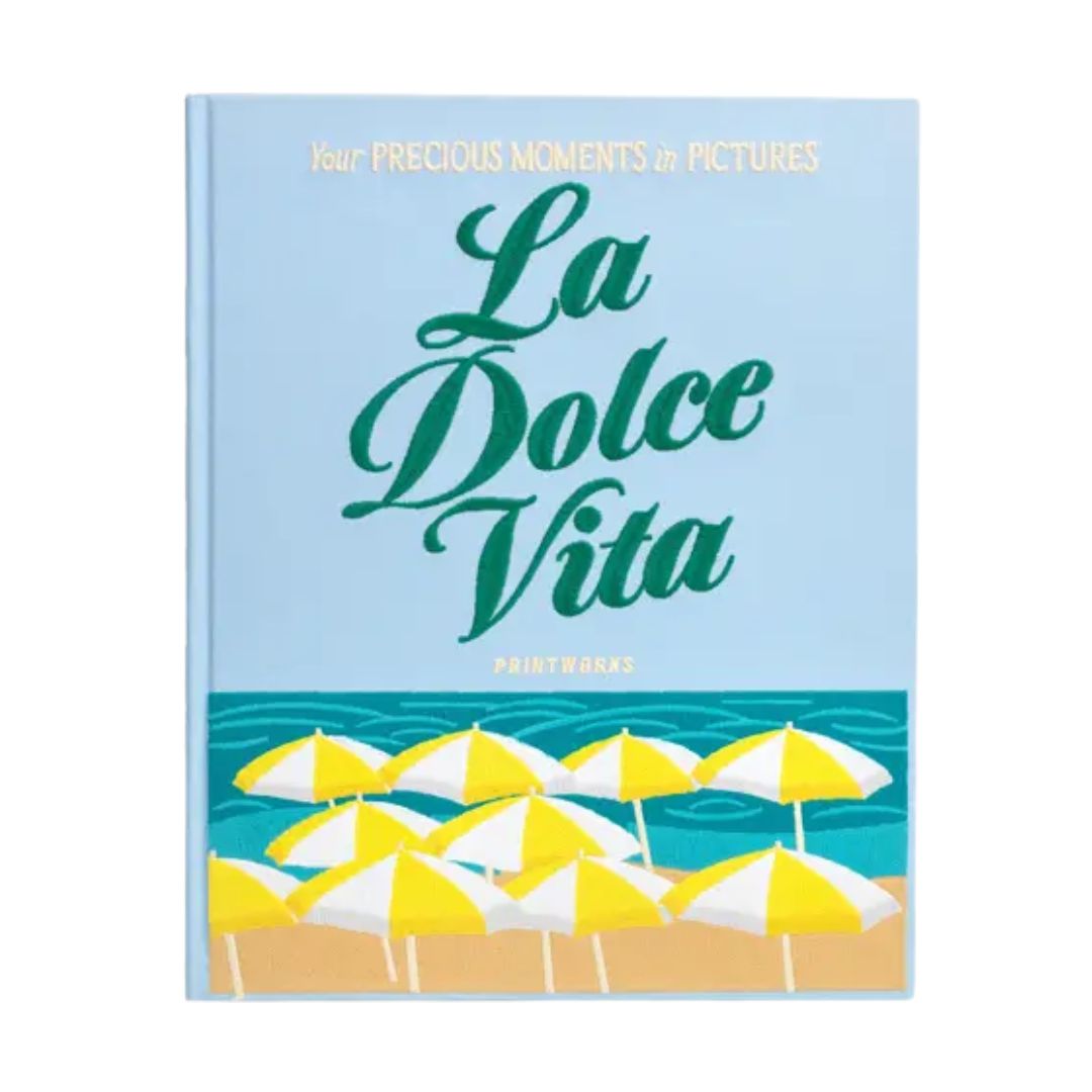 Printworks Dolce Vita embroidered photo album with blue cotton cover and colourful stitching displayed on a coffee table